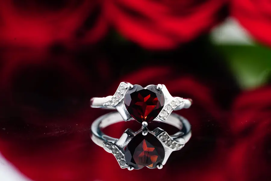 Red garnet ring with zircon accents showing deep red gemstone color in a finished jewelry setting